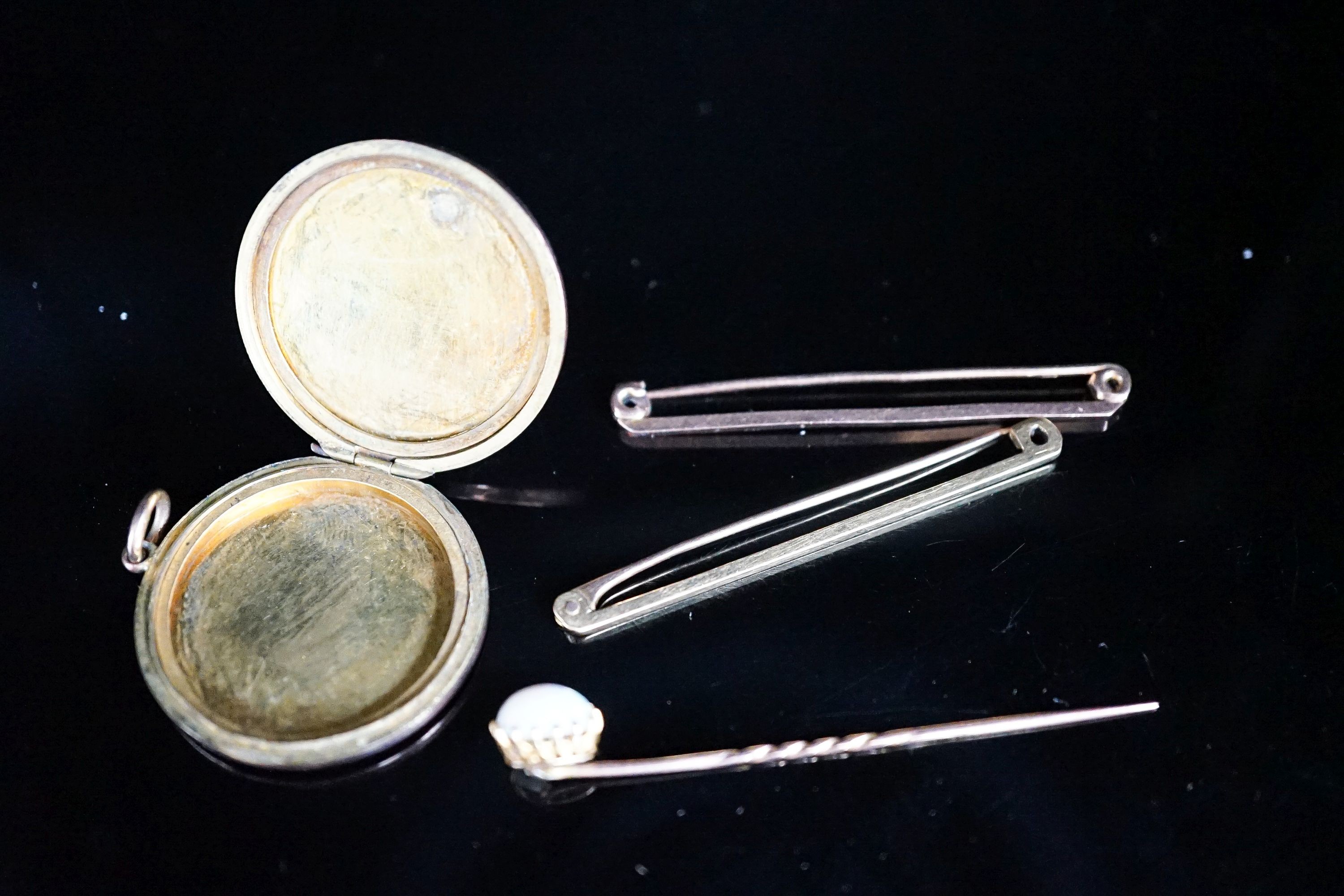 An 18ct bar brooch, 50mm, 2 grams, a 9ct bar brooch, 1.8 grams, a white opal set stick pin and a yellow metal locket.